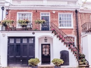 Elegant Two-Story Townhouse with External Staircase and Black Garage Door